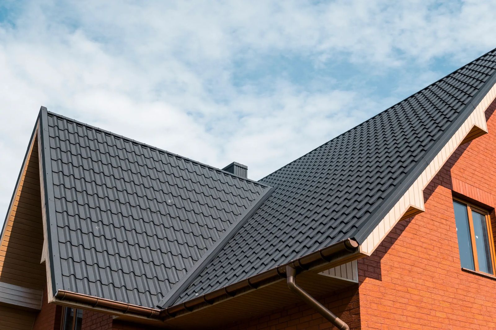 Newly tiled dark grey pitched roof on a brick house in Sunbury-on-Thames