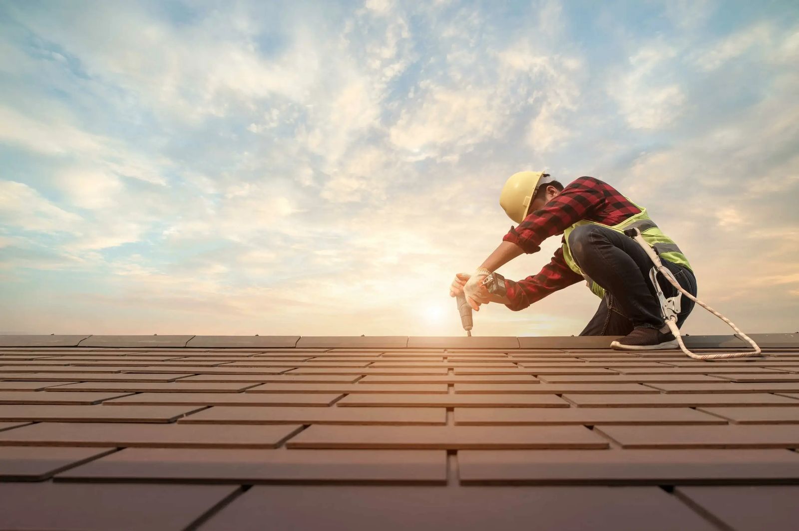 Roofer working on a tiled roof, tracing the cause of a leak